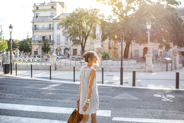 Mujer de negocios con estilo joven cruzando la calle en la ciudad vieja en Francia