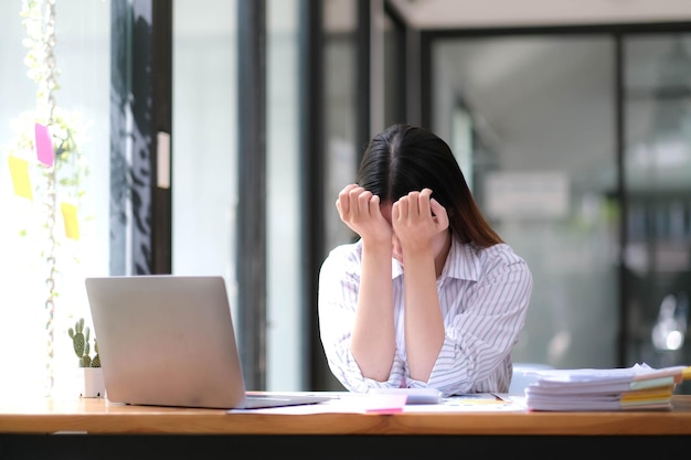 La mujer de negocios se estresa y tiene dolor de cabeza mientras tiene un problema