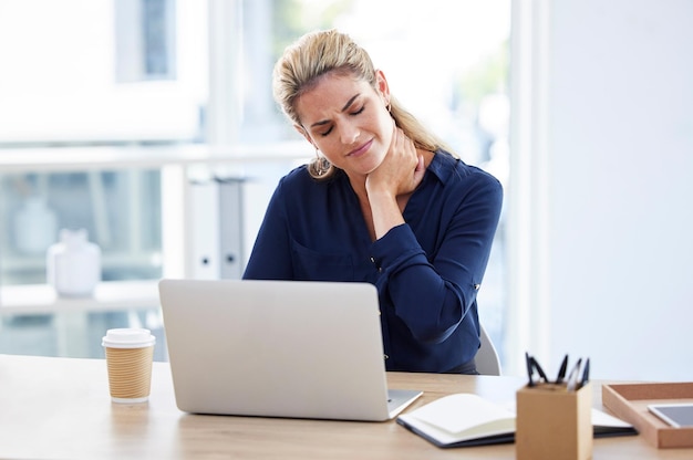 Mujer de negocios estresada en el lugar de trabajo con dolor de cuello en el escritorio y leyendo correo electrónico en una computadora portátil en la oficina de Londres Recepcionista que trabaja como joven con agotamiento o secretaria frustrada con crisis en la empresa