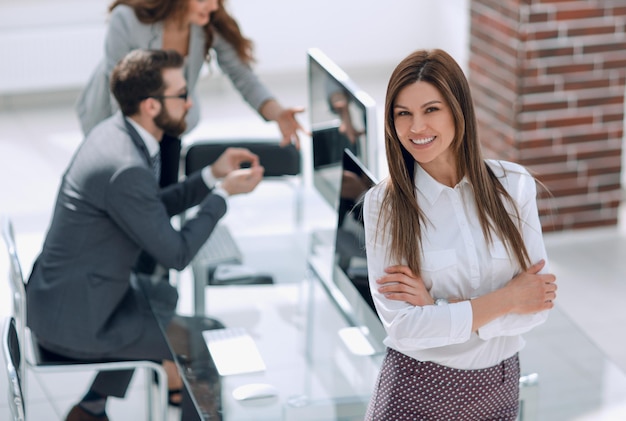 Mujer de negocios exitosa en el fondo de la foto de lugar de trabajo con espacio de copia