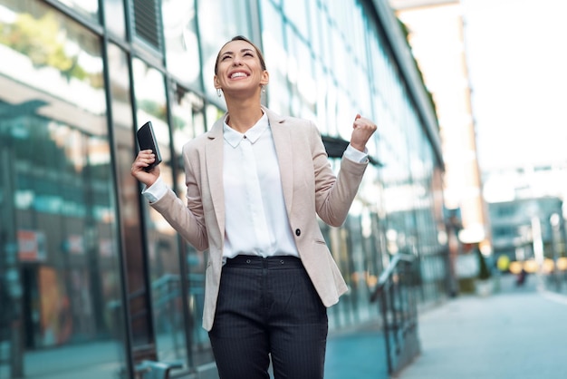 Mujer de negocios exitosa levantando las manos Mujer de negocios caminando al aire libre