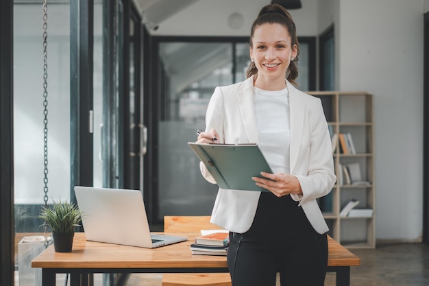 Mujer de negocios exitosa de pie en la oficina creativa y mirando a la cámara Mujer emprendedora en un espacio de coworking sonriendo