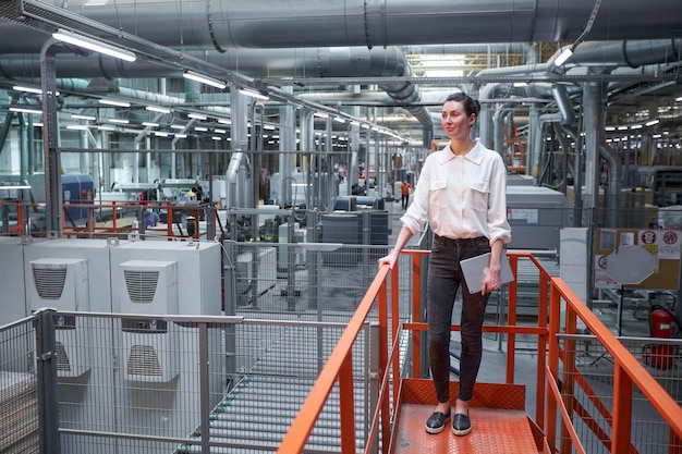 Foto mujer de negocios en la fábrica de carpintería industrial - producción de tableros de madera con máquinas modernas