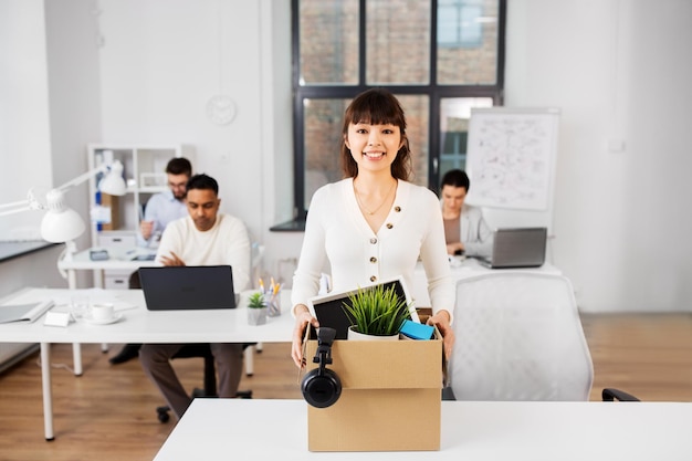 Foto mujer de negocios feliz con cosas personales en la oficina