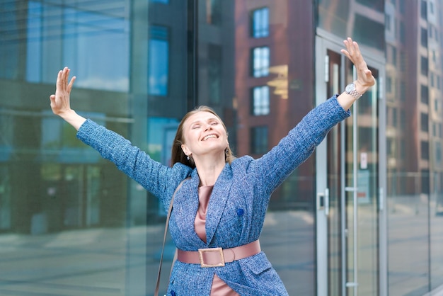 Foto mujer de negocios feliz mostrando los pulgares hacia arriba mientras está de pie al aire libre contra la oficina