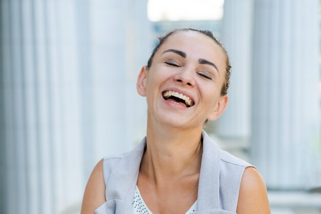 Foto mujer de negocios feliz riendo cerca del concepto de éxito del edificio