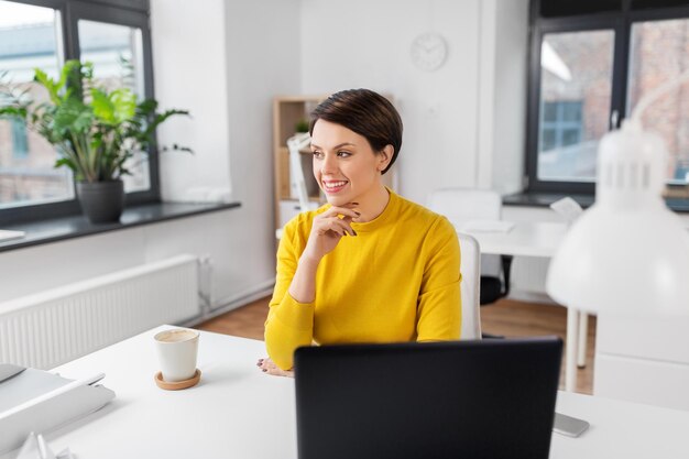 mujer de negocios feliz sentada en la mesa de la oficina