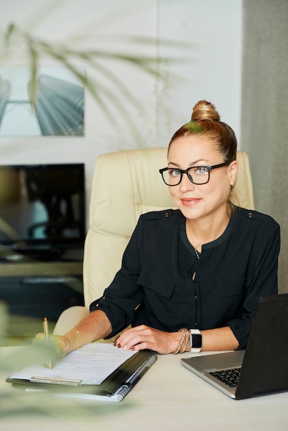 Mujer de negocios feliz en su mesa de oficina