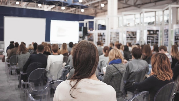 Mujer de negocios y gente escuchando en la imagen horizontal de la conferencia