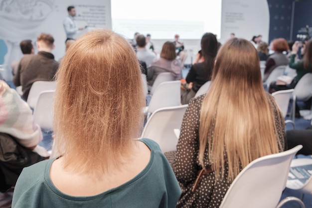 Mujer de negocios y gente escuchando en la imagen horizontal de la conferencia