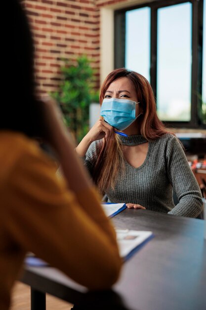 Foto mujer de negocios hablando con un cliente en la oficina durante la pandemia