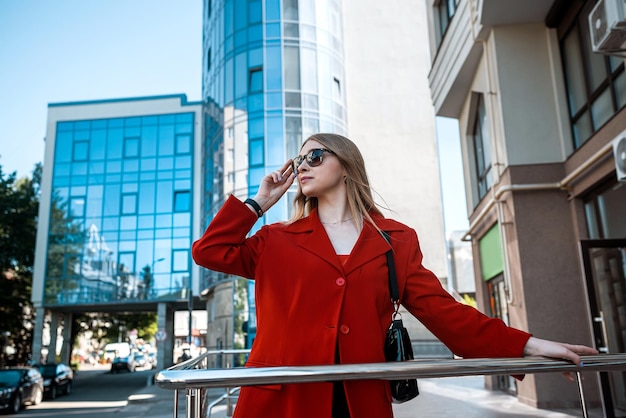 Mujer de negocios hablando por teléfono al aire libre con gente de negocios cerca de la oficina