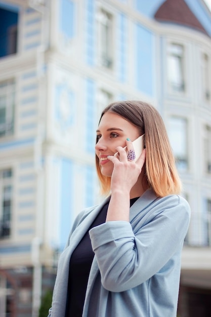 Mujer de negocios hablando por teléfono al aire libre. retrato, de, hermoso, niña sonriente, en, moderno, ofi