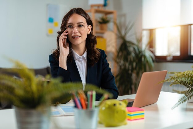 Mujer de negocios hablando por teléfono. Empresaria trabajando desde casa y usando el teléfono