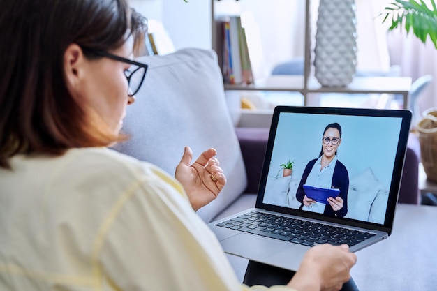 Mujer de negocios haciendo video chat con el socio del cliente en la oficina en casa