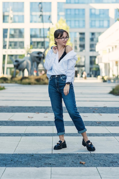 Mujer de negocios hermosa y exitosa en traje con documento caminando a la reunión cerca de la oficina moderna