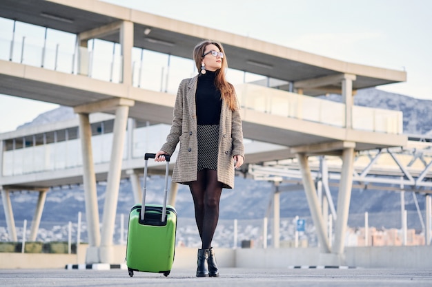 Mujer de negocios hermosa joven en el aeropuerto internacional con maleta