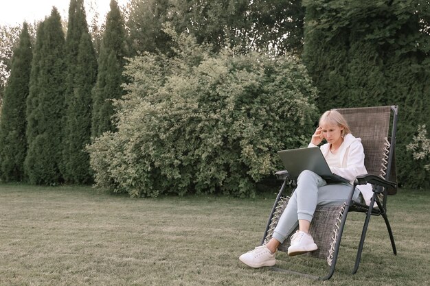 Mujer de negocios hermosa joven que trabaja en una computadora portátil independiente trabaja en la naturaleza