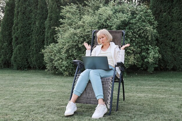 Mujer de negocios hermosa joven que trabaja en una computadora portátil independiente trabaja en la naturaleza