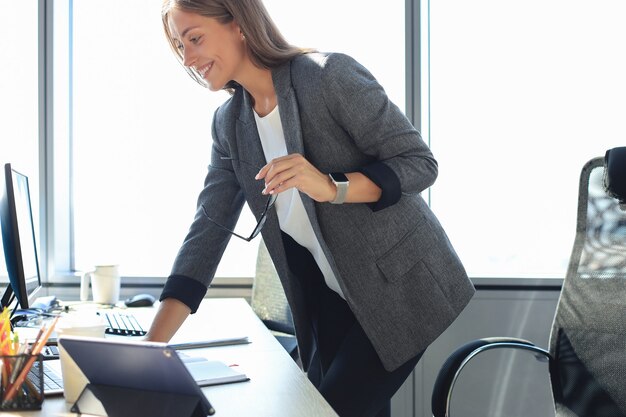 Mujer de negocios hermosa que trabaja en la computadora portátil en la oficina.