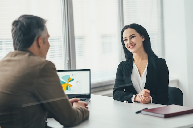 La mujer de negocios y un hombre hablando en la mesa de la oficina