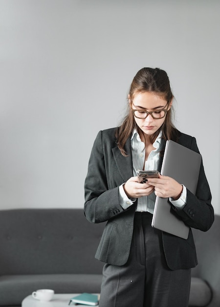 Mujer de negocios independiente usando una computadora portátil escribiendo en una computadora portátil navegando por Internet en la oficina Mujer de negocios informal haciendo una llamada telefónica