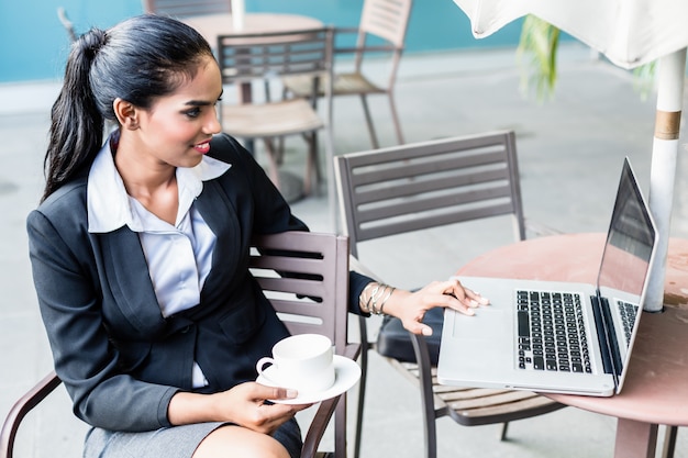 Mujer de negocios india que trabaja con la computadora portátil