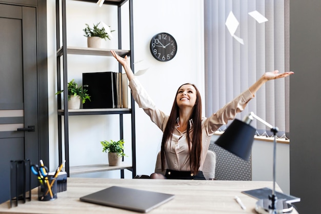 Mujer de negocios inteligente en traje formal sentada y estirada, relájese frente a la computadora con felicidad y sonrisa en el lugar de trabajo de la oficina moderna