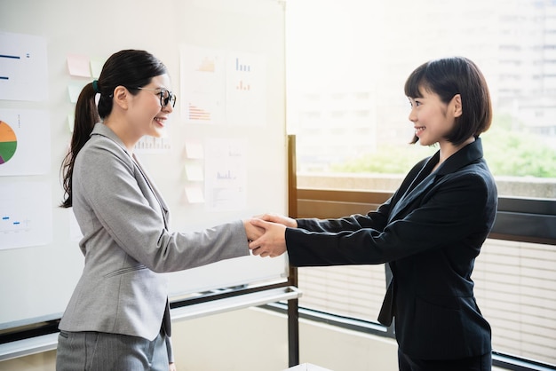 mujer de negocios japonesa agradecida y sellando un trato con su futuro socio comercial, dándose la mano
