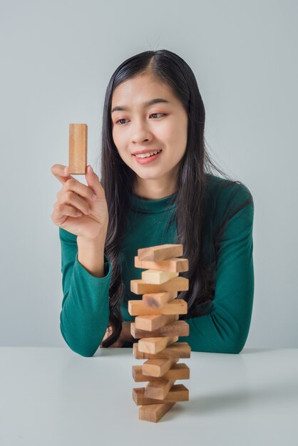 Mujer de negocios joven asiática jugando con bloques de madera