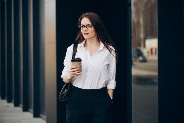 Mujer de negocios joven bebiendo café en el centro de negocios