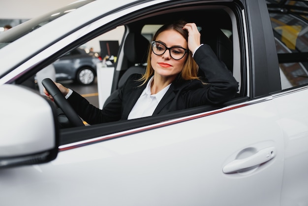 Mujer de negocios joven conduciendo en su coche al trabajo.