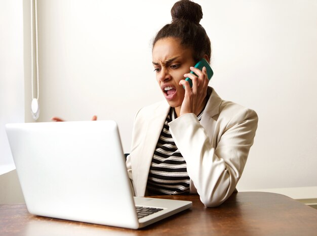 Mujer de negocios joven gritando en el teléfono