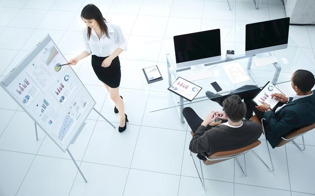 Mujer de negocios joven haciendo una presentación a su equipo empresarial