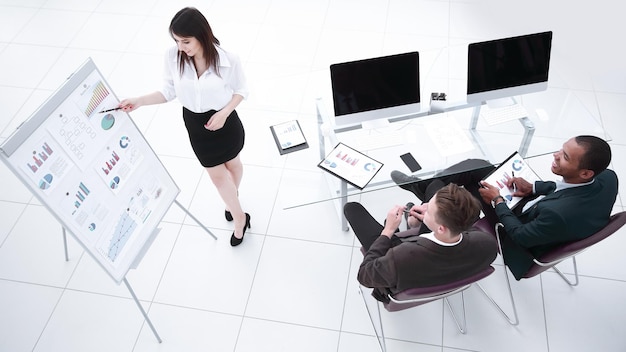 Mujer de negocios joven haciendo una presentación a su equipo empresarial