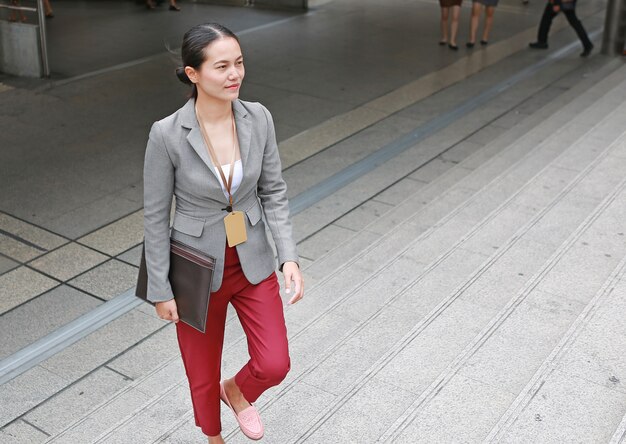 Mujer de negocios joven hermosa que camina afuera.