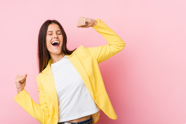 Mujer de negocios joven levantando el puño después de una victoria, concepto ganador.