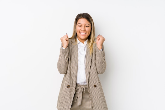 Mujer de negocios joven levantando el puño, sintiéndose feliz y exitoso
