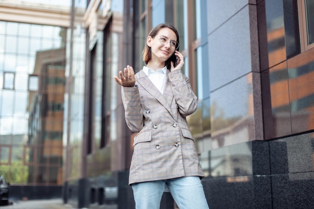 Mujer de negocios joven moderna hablando por teléfono en la ciudad