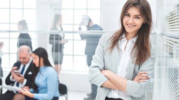 Mujer de negocios joven de pie en una oficina moderna. foto con espacio de copia