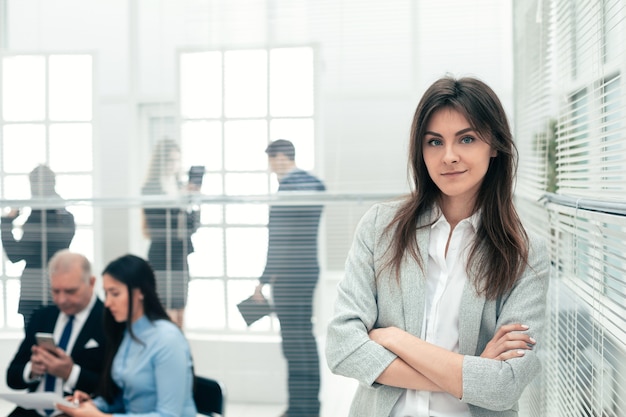 Mujer de negocios joven de pie en una oficina moderna. foto con espacio de copia