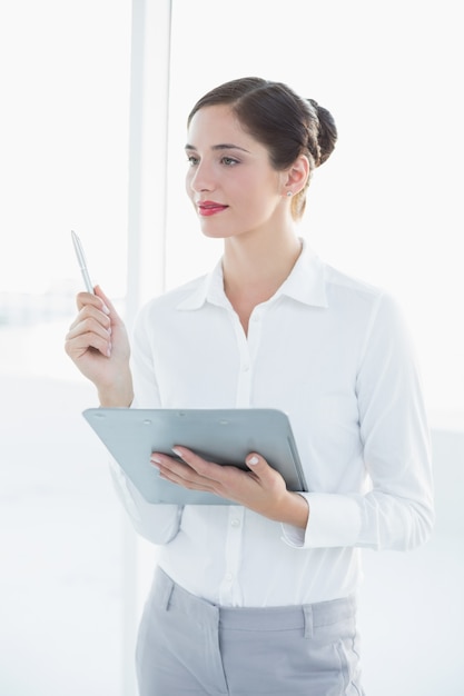 Mujer de negocios joven con portapapeles y pluma