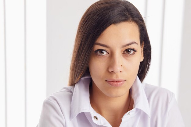 Mujer de negocios joven posando sobre fondo.