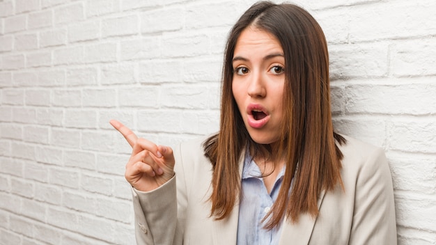 Mujer de negocios joven que señala al lado