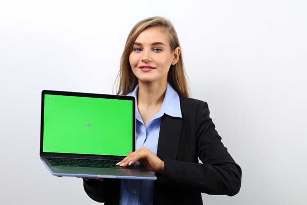 Foto mujer de negocios joven que sostiene la computadora portátil con pantalla verde para el concepto de negocio publicitario