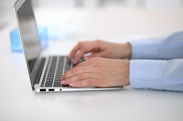 Mujer de negocios joven que trabaja en la computadora portátil en la oficina. Concepto de negocio exitoso.