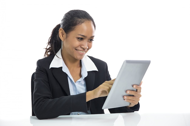 Mujer de negocios joven que trabaja en su tableta de la PC
