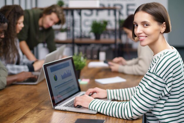 Mujer de negocios joven que usa una computadora portátil en un centro de coworking