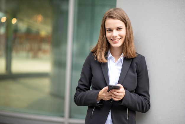 Mujer de negocios joven que usa su teléfono celular móvil