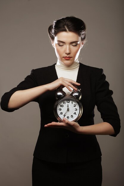 Mujer de negocios joven con un reloj despertador